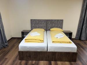 1 Schlafzimmer mit 2 Betten und gelben Kissen in der Unterkunft M&M Hotel - Seevetal in Seevetal