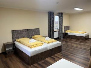 een slaapkamer met 2 bedden in een kamer bij M&M Hotel - Seevetal in Seevetal