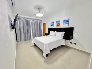 a bedroom with a white bed and a window at Luxury Tropical Paradise Villa 4B Heated Pool in Camú