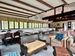 a large room with tables and chairs and windows at Estancia Jardín de Teresita in Tarqui