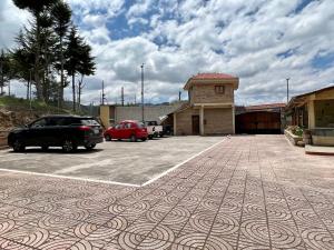 a parking lot with two cars parked next to a building at Estancia Jardín de Teresita 
