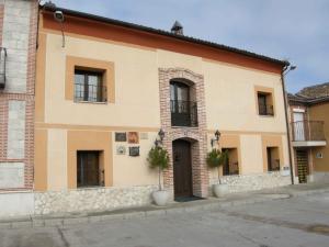 un edificio con ventanas y una puerta en una calle en La Posada de Carmen, en Chañe