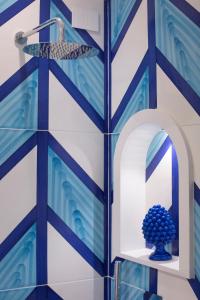 a blue and white wall with a mirror and a vase at AMORE RENTALS - Appartamento Luis 2 11 in Sorrento +36 photos