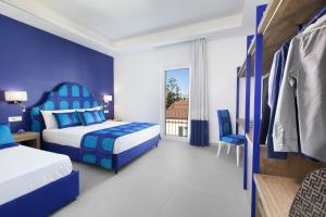 a blue and white bedroom with two beds and a window at AMORE RENTALS - Appartamento Luis 2 11 in Sorrento