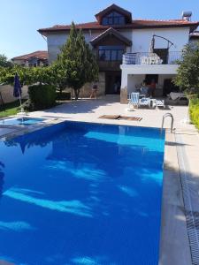 a large blue swimming pool in front of a house at 4 yatak odalı Harika müstakil villa in Manavgat