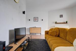 a living room with a couch and a television at Targowa 10 Modern 2BR Apt in Warsaw