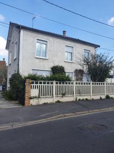 a white fence in front of a house at Maison le Diamant vert in Bezons