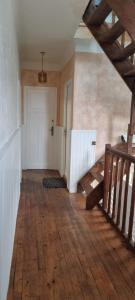 an empty room with a wooden floor and stairs at Maison le Diamant vert in Bezons