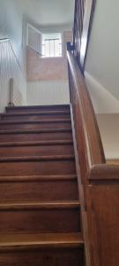 a staircase in a building with wooden stairs at Maison le Diamant vert in Bezons