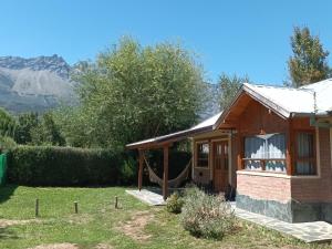 a small house with a hammock outside of it at Casa Peral in El Bolsón