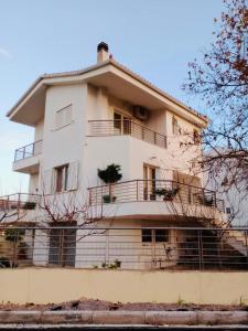 un edificio blanco con balcón en la parte superior en Homey Family ArtAki, en Néa Artáki