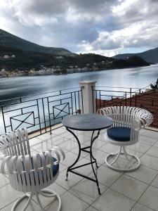 a table and chairs on a balcony with a view of the water at Port view Studios in Vathi