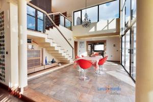 a dining room with a table and red chairs at Vivienda Vacacional Casa Erizo adults only in Nazaret