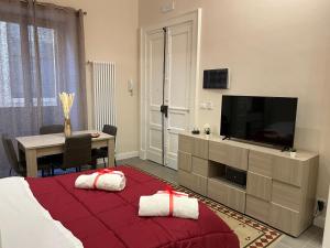 ein Schlafzimmer mit einem Bett und einem Tisch mit einem TV in der Unterkunft Genuardi’s apartment in Acireale