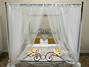 Bett mit Baldachin und weißen Vorhängen in der Unterkunft Genuardi’s apartment in Acireale