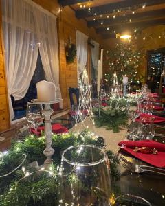 a table with christmas lights and wine glasses on it at Pensiunea Ioana in Rugineşti