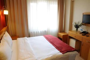 ein Hotelzimmer mit einem Bett und einem Fenster in der Unterkunft Cetinkaya Hotel in Canakkale