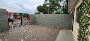 a fence in front of a brick courtyard with a gate at 300m-da Av das Cataratas- Ar Condicionado - Estacionamento Privado in Foz do Iguaçu