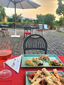 una tavola con un piatto di cibo e un bicchiere di vino di Agriturismo Podere La Fornace ad Assisi