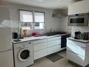 a kitchen with a washing machine and a dishwasher at Aulnay cocoon in Aulnay-sous-Bois
