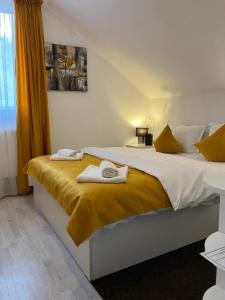 a bedroom with two beds with towels on them at Pensiunea Tinelu Brașov sacele in Braşov +68 photos