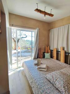 a bedroom with a bed and a large window at Arche de Noé atypique, bohème , nature, piscine chauffée de Pâques à Toussaint , spa , sauna , loisirs in Le Beausset