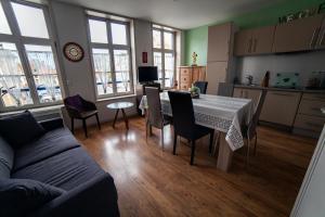 a kitchen and living room with a table and a couch at 2 Gites au coeur de Bergues in Bergues