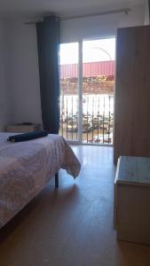 1 dormitorio con cama y vistas a un aparcamiento en TOMMY ROOMS, en Alicante