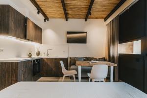 eine Küche und ein Esszimmer mit einem Tisch und Stühlen in der Unterkunft Suite Homes - Fine Living , Preveza in Kanali