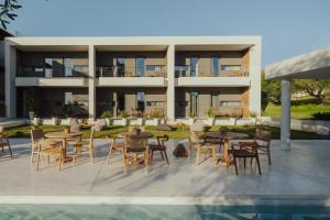 einen externen Blick auf ein Resort mit Tischen und Stühlen in der Unterkunft Suite Homes - Fine Living , Preveza in Kanali
