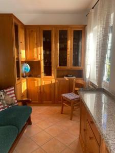 a kitchen with wooden cabinets and a green couch at Casa Laura in Zoagli