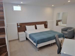 1 dormitorio con cama, silla y espejo en apartamento, en Adeje