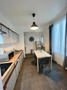 a kitchen with a table and a dining room at Super appartement chaleureux à 30min de Paris in Gagny