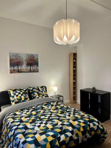een slaapkamer met een bed en een kroonluchter bij Super appartement chaleureux à 30min de Paris in Gagny