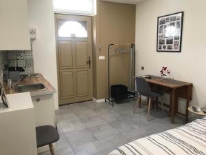 - une cuisine avec un évier et un bureau dans la chambre dans l'établissement Studette de 17m2 avec parking privé gratuit Climatisation et petite cuisine, à Menton