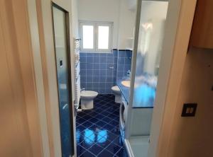 ein blaues Badezimmer mit WC und Waschbecken in der Unterkunft Casa Fe in Triest