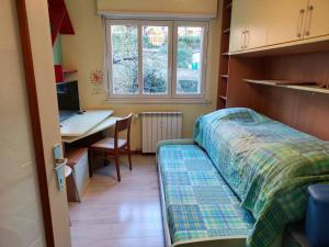 Schlafzimmer mit einem Bett und einem Schreibtisch mit einem Computer in der Unterkunft Casa Fe in Triest