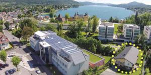 an aerial view of a city with a building with solar panels on it at Apartment Velden - Angelika Berginz in Velden am Wörthersee