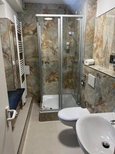 ein Bad mit einer Dusche, einem WC und einem Waschbecken in der Unterkunft M&M Hotel - Seevetal in Seevetal