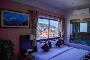 een hotelkamer met een bed en een groot raam bij Hotel Shaara in Pokhara