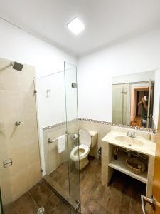 a bathroom with a toilet and a shower and a sink at Puesta del Sol Guest House in San Andrés