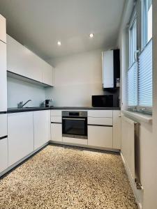 a kitchen with white cabinets and a sink and a stove at Zentrum: Prater, Messe, WU in Vienna
