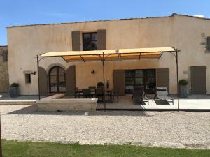 a patio with a table and chairs in front of a building at Ferme La Clavière, Gîte Lou Mas in Mane