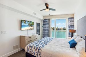 um quarto com uma cama, uma televisão e uma janela em Oceana 301 East em St. Pete Beach