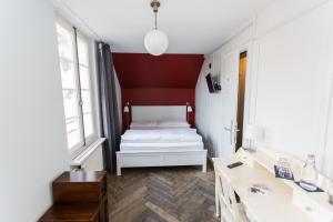 
a bedroom with a bed and a dresser at Hotel Landhaus in Bern
