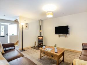 een woonkamer met een bank en een tv bij Marchlyn in Caernarfon