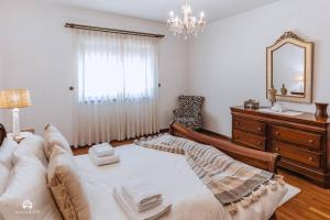 - une chambre avec un lit, une commode et un miroir dans l'établissement Casa do Pátio - 3 Bedrooms, Ponte Rol, à Torres Vedras