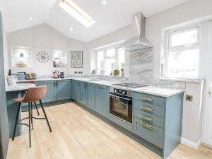 a kitchen with blue cabinets and a counter at Pengwern Bach in Llanrwst