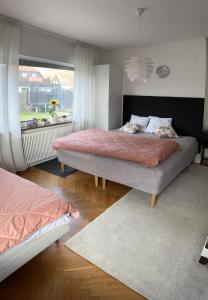 a bedroom with two beds and a large window at Brabo2 in Landskrona