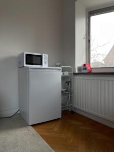 a microwave sitting on top of a refrigerator in a room at Brabo2 in Landskrona